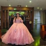 Entrada de quinceañera con vestido rosa al templo durante misa de XV años