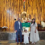Captura emotiva de familia participando en sacramento de bautizo.