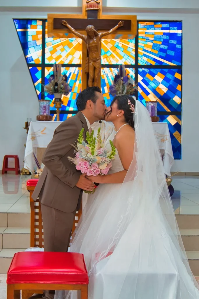 Bendición del sacerdote a los novios durante ceremonia de boda en templo católico.