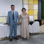 Pareja frente a mesa principal decorada en aniversario de bodas cristiano de 30 años.