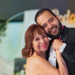 Sesión fotográfica de aniversario de bodas con madre. hijo sonrientes y fondo decorativo personalizado.