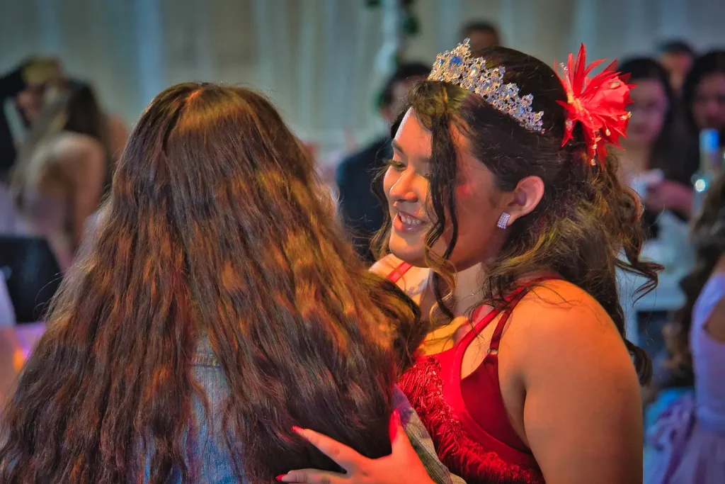 Foto grupal con Valeria y familiares en salón decorado durante su fiesta de quince años.