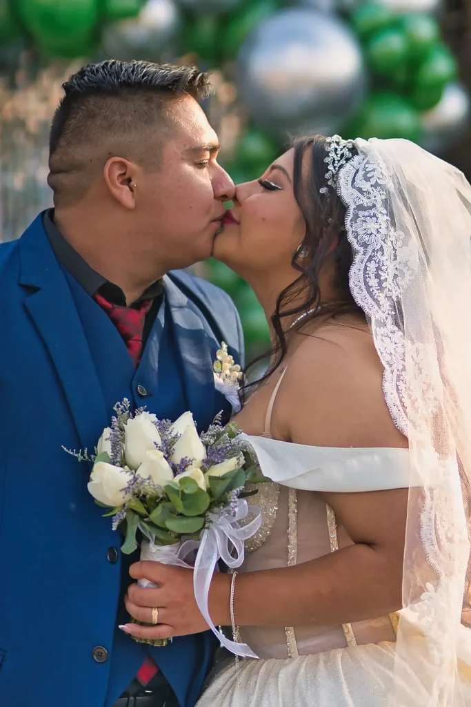 Beso romántico de los novios durante sesión de fotos en su boda.