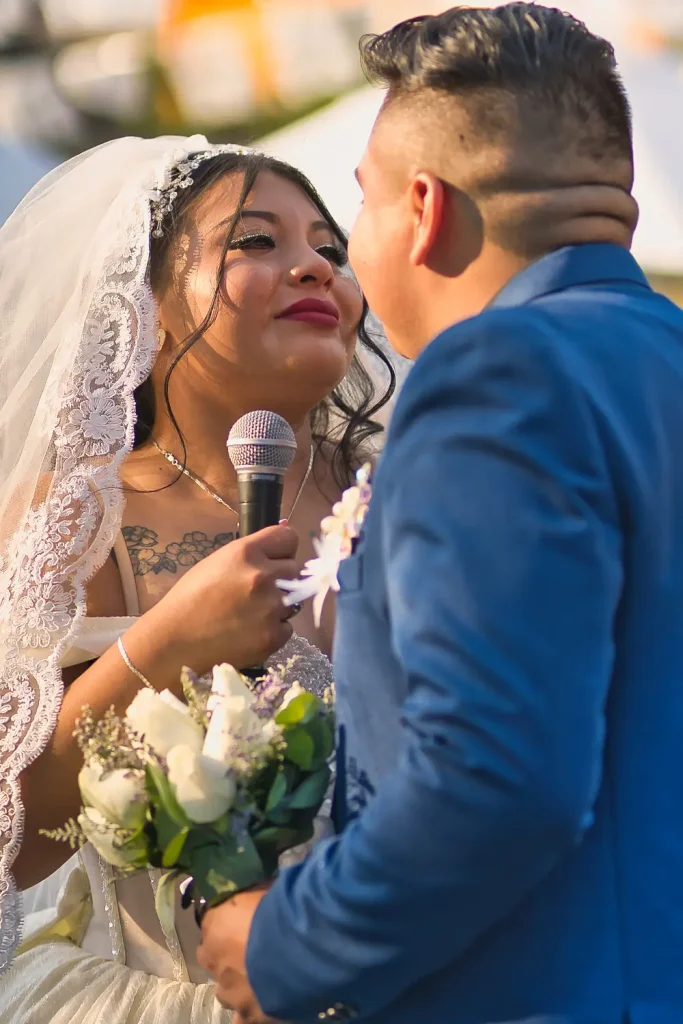 Novios besandose y compartiendo palabras emotivas en celebración de su matrimonio.