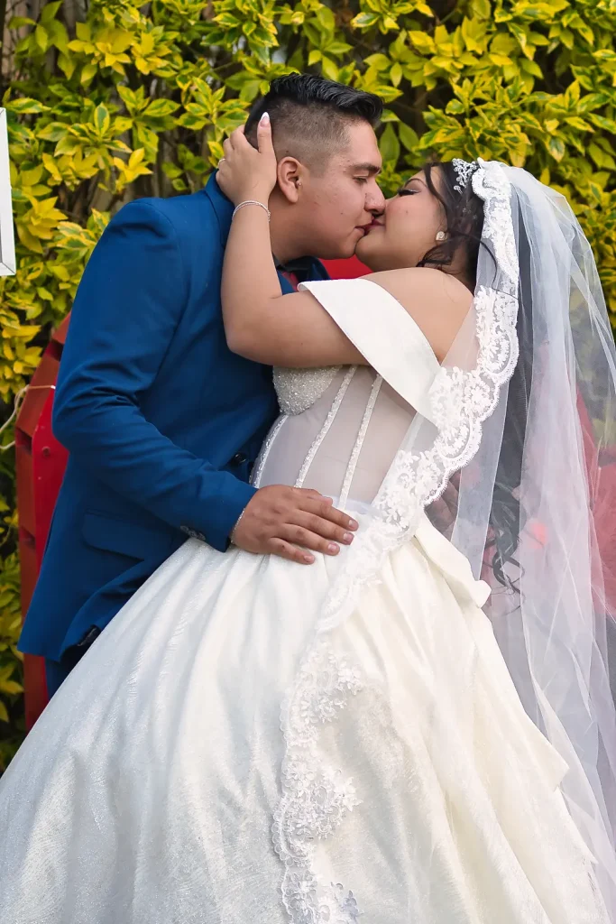 Beso apasionado de Jeimie y Juan en sesión fotográfica de boda al aire libre.