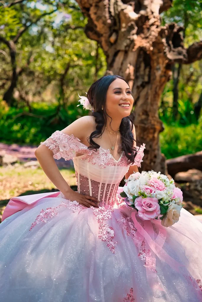 Crystal sonriendo con ramo floral en sesión profesional de XV años en bosque.