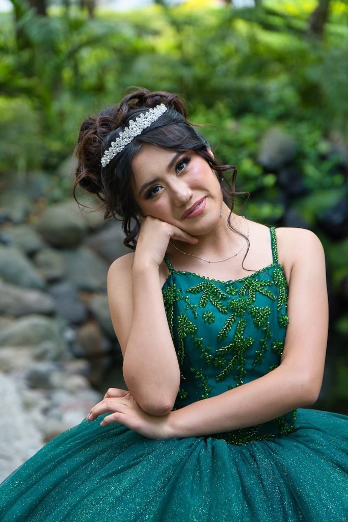 Fernanda con vestido verde esmeralda posando durante sesión fotográfica de XV años en Los Pinos.