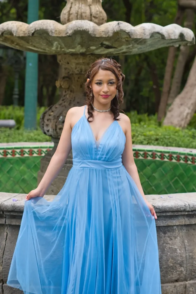Dany posando frente a fuente en jardín del Complejo Cultural los Pinos en CDMX durante sesión profesional de XV años.